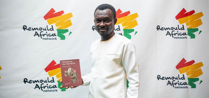 Godwin Kwame Tamakloe com um exemplar de Reshaping the Narrative no lançamento